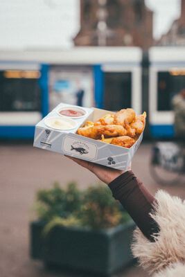 Fish & Fries with an Amsterdam tram and the Munttoren tower in the background