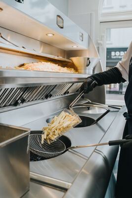 Chef at work behind the counter with the arched window behind him