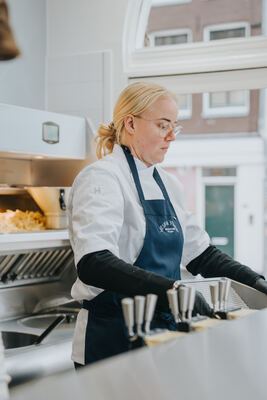 Staff member preparing orders at the stainless steel counter